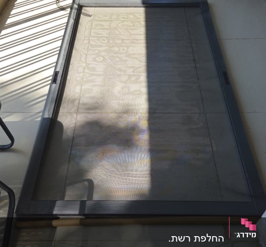 רשת חלון על רצפת מרפסת עם צמח בעציץ